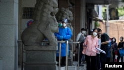 北京市民在一中国建设银行支行前排队等候进行新冠核酸检测。(2022年6月6日)