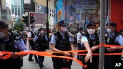 Police officers set up cordon line near the Hong Kong's Victoria Park, Saturday, June 4, 2022.
