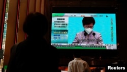 香港民众观看特首林郑月娥宣布不参选连任的电视报道(路透社2022年4月4日)