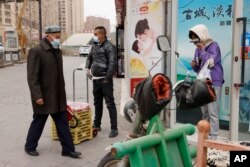 戴着口罩的民众在新疆街头。新疆伊犁自治州伊宁县的民众表示,在因为新冠病毒而封控40多天后,他们正在经历饥饿和强迫隔离(资料图片)