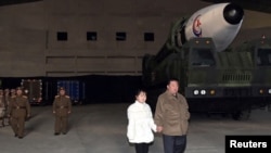 2022年11月19日,朝鲜领导人金正恩手牵着他女儿金主爱(Kim Ju Ae)的手视察一枚朝鲜制造的洲际弹道导弹。该照片由朝中社发布,路透社提供。
