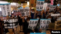 日本民众在东京举牌反对9月27日为前首相安倍晋三计划举行的国葬。(2022年9月25日)
