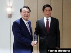 韩国总统尹锡悦(左)在首尔龙山总统府会见到访的中国全国人大常委会委员长栗战书。(2022年9月16日)