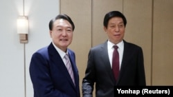韩国总统尹锡悦(左)在首尔龙山总统府会见到访的中国全国人大常委会委员长栗战书。(2022年9月16日)