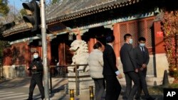 北京当局因一例新冠阳性封闭北京大学。中国警察和保安站在北京大学前监控校门。(2022年11月16日)