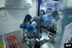 北京举行的2022世界机器人大会展示一个可以做新冠核酸检测的机器人。(2022年8月18日)