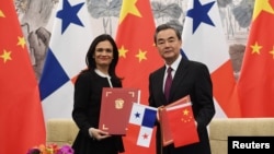 中国外长王毅(右)和巴拿马副总统兼外交部长伊莎贝尔·德圣马洛在北京签署两国建立外交关系的联合公报。(2017年6月13日)