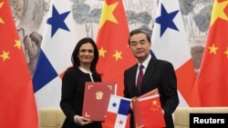 中国外长王毅(右)和巴拿马副总统兼外交部长伊莎贝尔·德圣马洛在北京签署两国建立外交关系的联合公报。(2017年6月13日)