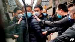 资料照片:警方在搜查香港《立场新闻》办公室后带走该媒体的编辑林绍桐。(2022年1月4日)