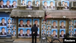 资料照:上海街头一座建筑物的墙上贴满了中国领导人习近平的肖像。(2016年3月26日)