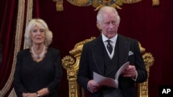 英国新国王查尔斯三世,坐在他身后右边的是卡米拉王后。(美联社照片)