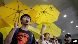 香港青年学生领袖黄之锋(左)与支持者在香港裁判法院外呼喊口号。(2015年9月2日)