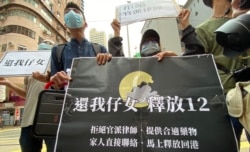 多名被关押盐田看守所的港人家属9月30日手持写上4大诉求的标语,由西区警署游行到北京驻港机构中联办外请愿,要求释放12港人 (美国之音/汤惠芸)
