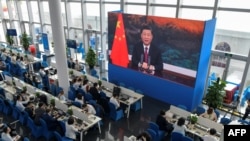 采访博鳌论坛的记者们在媒体厅观看屏幕上显示的中国国家主席习近平在开幕式上讲话的视频。(2021年4月20日)