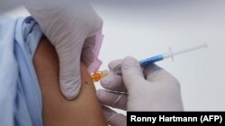 资料照片:德国东部一所大学医院正在给人注射默德纳公司生产的疫苗(2021年1月22日)