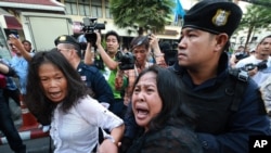 5月24日曼谷发生反政变示威,警察要拘押一位妇女,另一位妇女试图帮助她。