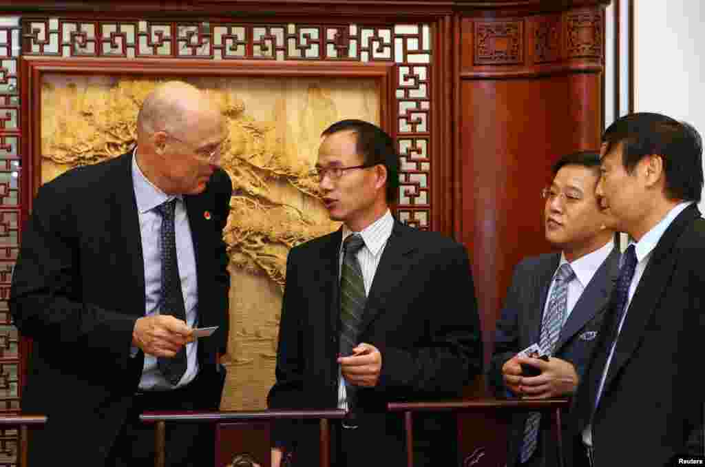 2006年9月19日,美国财政部长保尔森和中国工商业人士在晚宴前交换名片