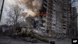 Український військовий намагається сховатись під час російського авіаудару по Авдіївці, 17 березня 2023 року. Фото AP