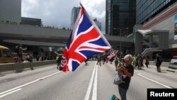 一名香港抗议者手持英国国旗。(2019年6月21日)