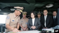 一艘台湾海军船舰起航到南中国海巡逻之前,台湾总统蔡英文(中)在高雄港海军基地登上这艘船舰并审视航海地图. (台湾总统府照片)