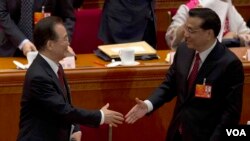 2013年3月5日即将离任的中国总理温家宝在第十二届人大开幕式上和他预计的继任者副总理李克强握手。(美国之音东方拍摄)