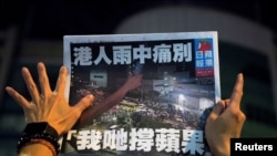 一名苹果日报的支持者手拿最后一期的苹果日报。(路透社2021年6月24日)