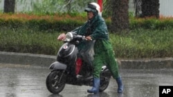 “摩羯”台风星期六下午1时在越南北部岛屿登陆,强风豪雨下,河内一名男子被破牵引机车。(美联社:2024年9月7日)