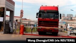 中国发现非洲猪瘟后,河南省郑州肉类加工企业双汇集团大门处可以看到身着防护服的工人。(2018年8月17日)