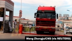 中国发现非洲猪瘟后,河南省郑州肉类加工企业双汇集团大门处可以看到身着防护服的工人。(2018年8月17日)