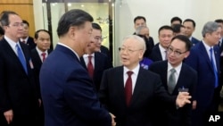 资料照片:2023年12月12日,中国国家主席习近平(左)和越南总书记阮富仲在越南河内握手。(美联社照片)