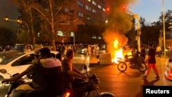 伊朗民众在德黑兰焚烧警车,为在伊朗警察局死亡的女子阿米尼(Mahsa Amini)举行抗议活动。(2022年9月19日)