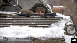 2022年1月28日,在乌克兰东部卢甘斯克地区的前线阵地附近,一名乌克兰军人从装甲运兵车上向外凝视。(美联社)