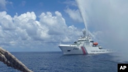 2015年9月23日,中国一艘海警船在南中国海黄岩岛附近接近菲律宾的一艘渔船。(资料照片)