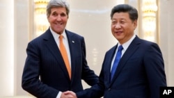 美国国务卿克里(左)在北京人大会堂与中国国家主席习近平举行会谈前握手。(2016年1月27日)