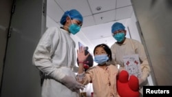 4月15日在北京地坛医院,一名先前被诊断感染H7N9禽流感病毒的女孩从急症病房转到普通病房