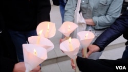 示威者在中国驻英大使馆外点燃蜡烛悼念六四死难者。 (美国之音郑乐捷)