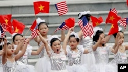 越南河内总统府,越南儿童在美国总统特朗普的欢迎仪式前挥舞国旗(2017年11月12日)。