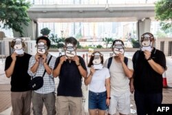 资料照:支持民主的香港跨工会联盟的支持者2021年7月23日在西九龙法院外戴上羊面具抗议。该工会成员现在因“羊村”系列儿童绘本被警方国安处人员拘捕,指控他们涉嫌“串谋刊印、发布、分发、展示或复制煽动刊物”罪。