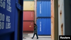一名俄罗斯海关官员走过加里宁格勒港口堆积的中国集装箱货柜。(2021年10月28日)