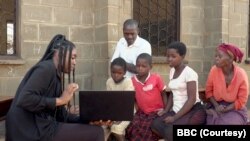 英国广播公司BBC记者鲁纳科·塞利纳向马拉维孩子展示“黑鬼”视频(BBC授权使用)