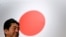 រូបឯកសារ៖ លោក Shinzo Abe អតីតនាយករដ្ឋមន្ត្រីជប៉ុន ឈរនៅមុខទង់ជាតិជប៉ុន ក្រោយពីចូលរួមសមាជបក្សប្រជាធិបេតយ្យសេរីនិយម (LDP) នៅទីក្រុងតូក្យូ ប្រទេសជប៉ុន កាលពីថ្ងៃទី ៥ ខែមីនា ឆ្នាំ ២០១៧។