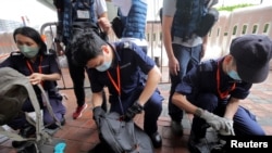 资料照片:2022年6月30日,中国香港警方在香港西九龙火车站外的媒体工作位置检查记者的包。(路透社照片)