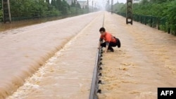中国江西上饶一名铁路工人在暴雨后检查被洪水淹没的铁轨情况。(2022年6月21日)