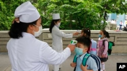 (资料照)2020年6月3日,朝鲜平壤一所小学学生在进入学校前接受体温测量。