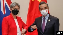 资料照:在印尼度假胜地巴厘岛努沙杜瓦举行的二十国集团外长会议期间,澳大利亚外交部长黄英贤(左)与中国外交部长王毅碰肘互致问候。(2022年7月8日)
