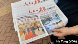7月1日香港主權移交25周年紀念日,灣仔街頭有人派發簡體字的中國官方《人民日報》海外版。(美國之音 湯惠芸)