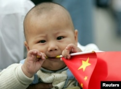 资料照:一个中国幼儿手拿一面中国国旗。