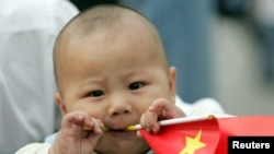 资料照:一个中国幼儿手拿一面中国国旗。