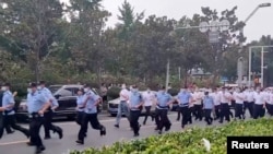 资料照:中国警察跑向河南郑州中国人民银行支行前抗议银行冻结存款的储户们。(2022年7月10日)