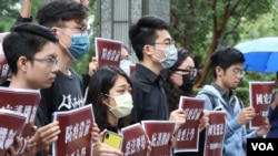 台港青年学生团体5月28日在台北的香港经贸办事处前举牌呼吁:“恶法压境齐心共进”、“防疫当前也要上学”。(美国之音李玟仪摄)